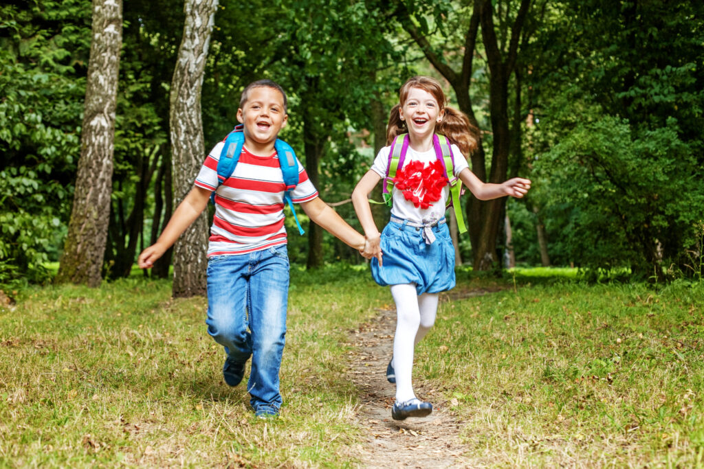 Children hold hands. Students running in the park. The concept i