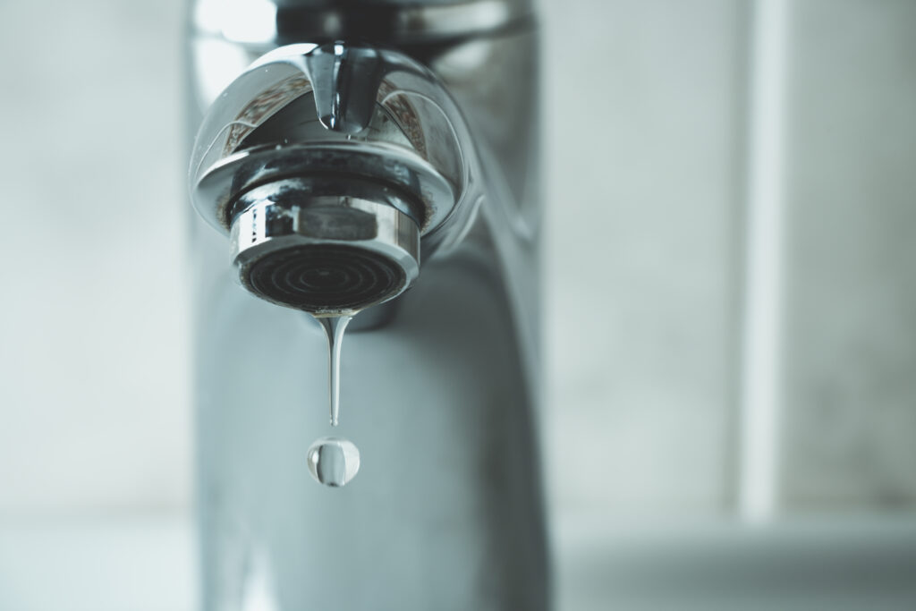 water drop dripping from the tap and water shortage