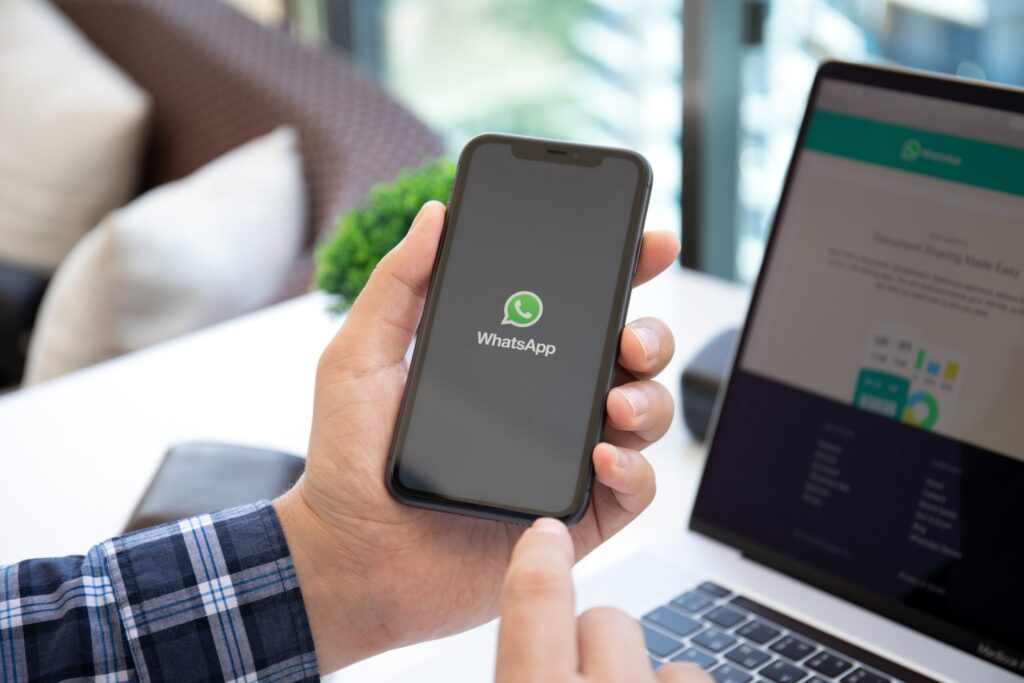 Man holding iPhone 11 with social networking service WhatsApp Man holding iPhone 11 with social networking service WhatsApp