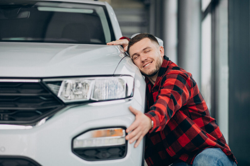 young man choosing a car in a car showroom young man choosing a car in a car showroom