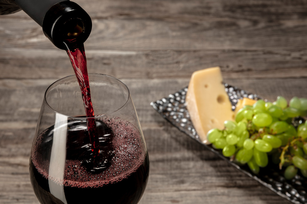 a-bottle-and-a-glass-of-red-wine-with-fruits-over-wooden-table a-bottle-and-a-glass-of-red-wine-with-fruits-over-wooden-table