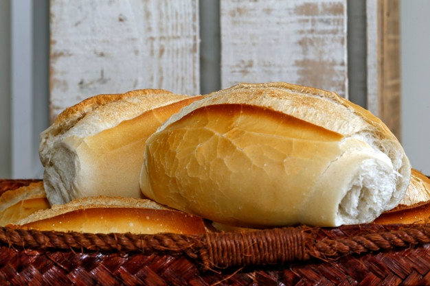 cesta-de-pao-frances-em-fundo-de-madeira-rustico_74436-529