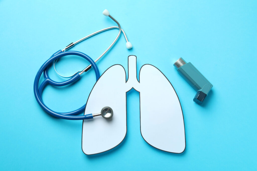 Decorative lungs, stethoscope and inhaler on blue background Decorative lungs, stethoscope and inhaler on blue background