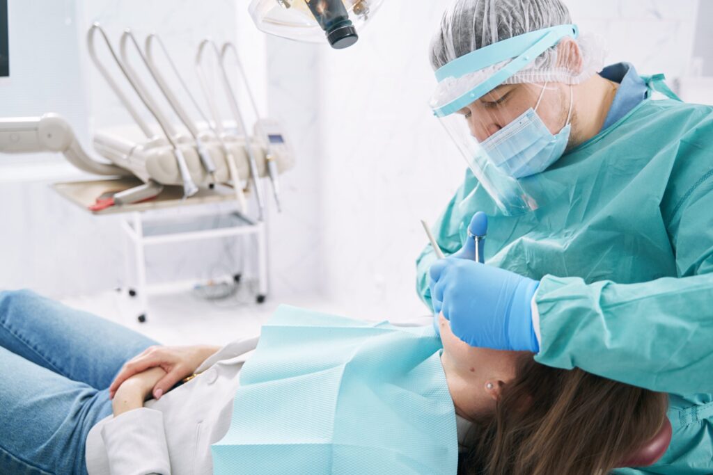 Dentist performing dental treatment in stomatology clinic Dentist performing dental treatment in stomatology clinic