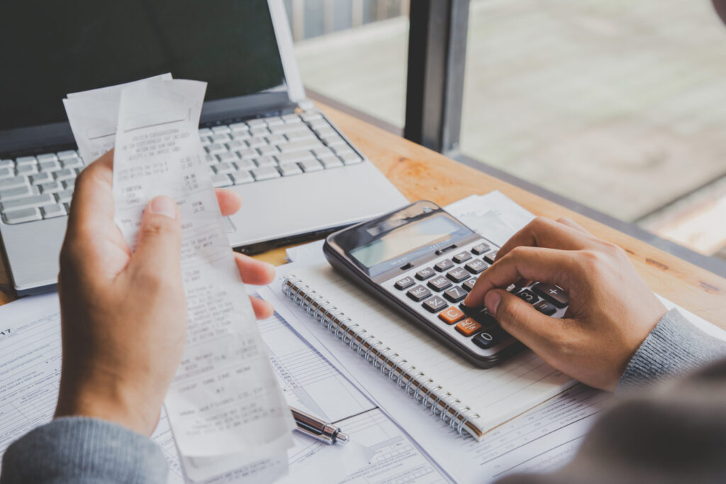Young man using calculator and calculate bills in home office. Young man using calculator and calculate bills in home office.