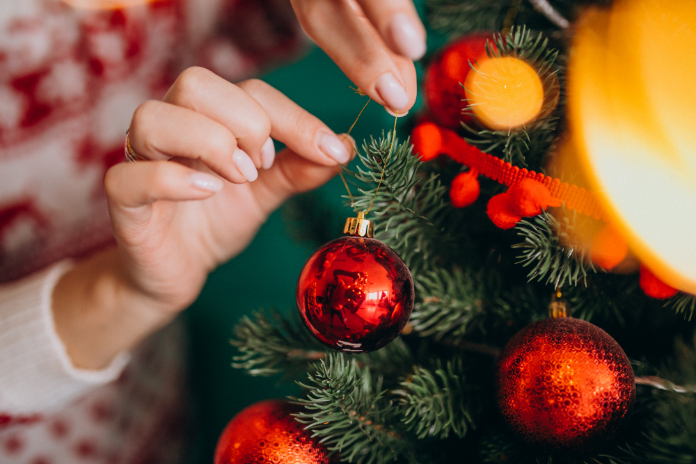 female-hands-close-up-decorating-christmas-tree-with-red-balls female-hands-close-up-decorating-christmas-tree-with-red-balls