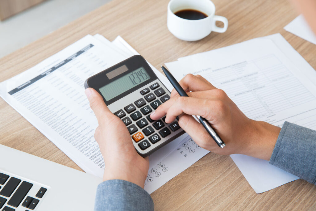 Man using calculator to count income and outcome Man using calculator to count income and outcome