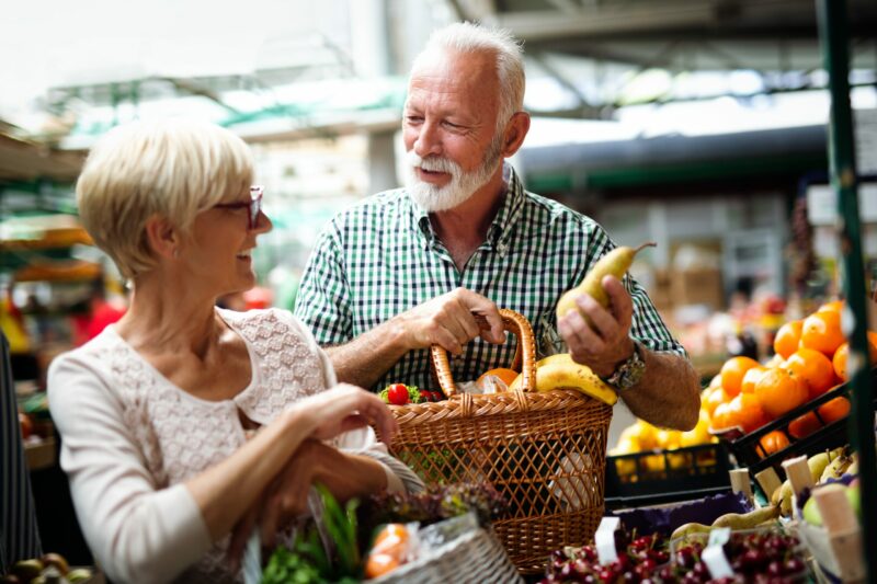 Senior family couple choosing bio food fruit and vegetable on the market during weekly shopping