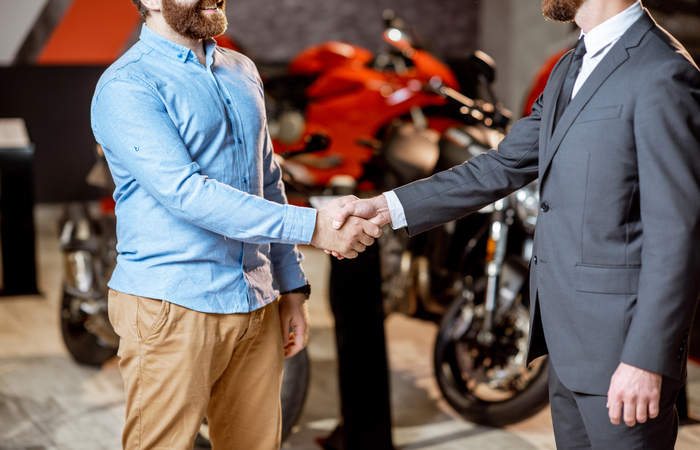 Handshake in the showroom with motorcycles Handshake in the showroom with motorcycles