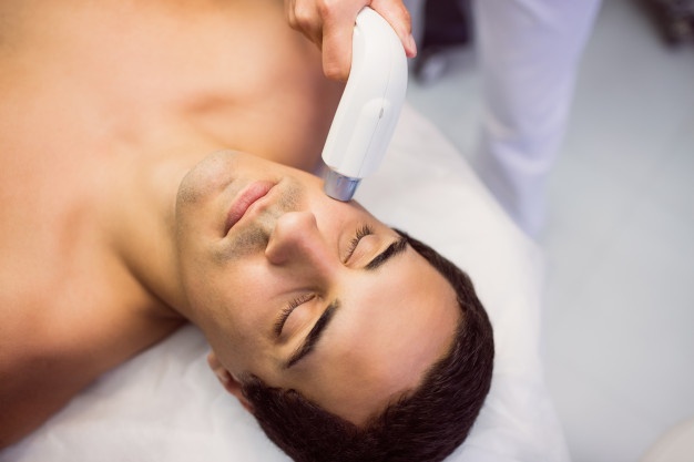 homem-recebendo-uma-massagem-facial-na-clinica_107420-65207