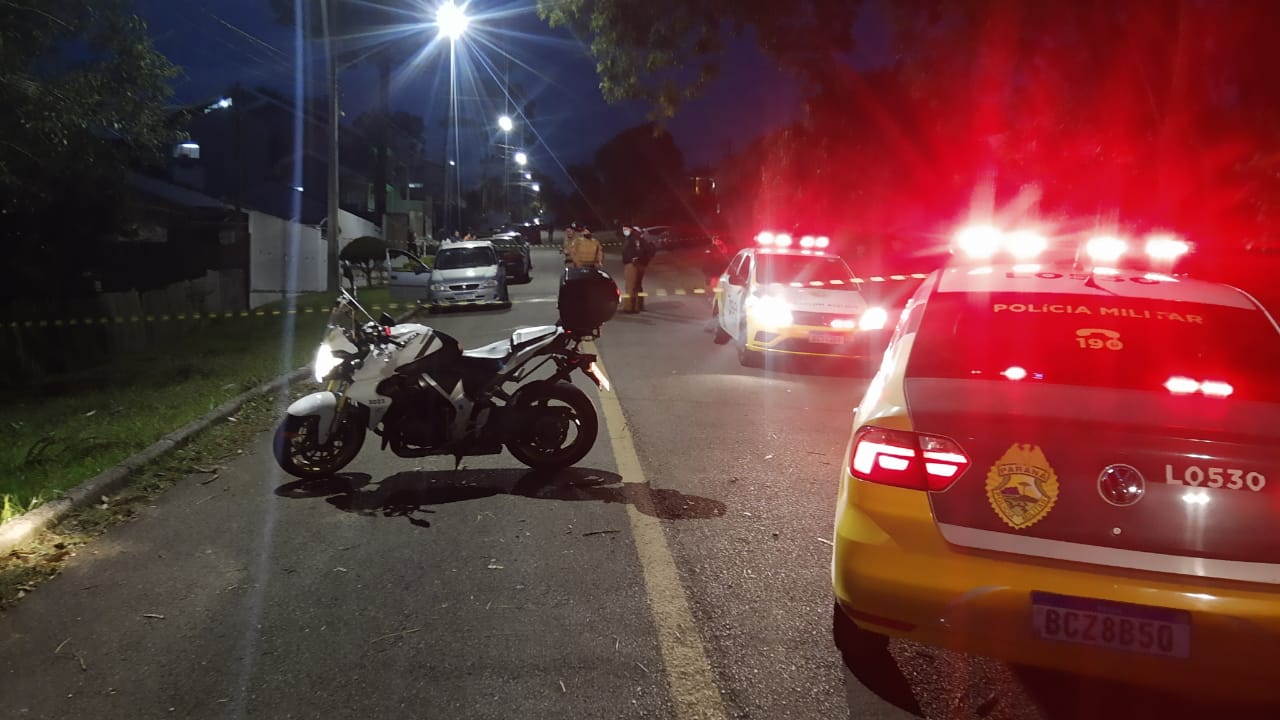 Uma mulher foi assassinada a tiros dentro do próprio carro na tarde deste sábado (22) no Bairro Alto, em Curitiba. A vítima foi identificada como Meire Cristine Bona e o principal suspeito do crime é o ex-marido dela – apenas o primeiro nome dele, Ivo, foi divulgado oficialmente. A filha de Meire também estava dentro do carro e acabou baleada, mas seu quadro de saúde é estável. Conforme foi apurado no local do crime, o carro estava parado quando o autor chegou de moto e atirou contra a ex, atingindo também a filha dela. Em seguida, o autor fugiu e tentou tirar a própria vida. O irmão dele presenciou toda a cena e tentou impedir o suicídio, mas acabou levando um tiro na perna. Em seguida, Ivo decidiu fugir do local e abandonou o irmão ferido. Policiais militares do 20º Batalhão tinham as características do suspeito e rapidamente conseguiram encontrá-lo. A arma do crime, no entanto, não tinha sido apreendida até a publicação desta matéria. O suspeito foi preso em flagrante e conduzido até a Central de Flagrantes. O corpo de Meire foi recolhido pelo Instituto Médico Legal (IML) de Curitiba e, até a publicação desta matéria, não havia informações sobre local de velório e sepultamento. Ela deixa três filhos. Colaboração de Douglas Bandeira, da Rede Massa.