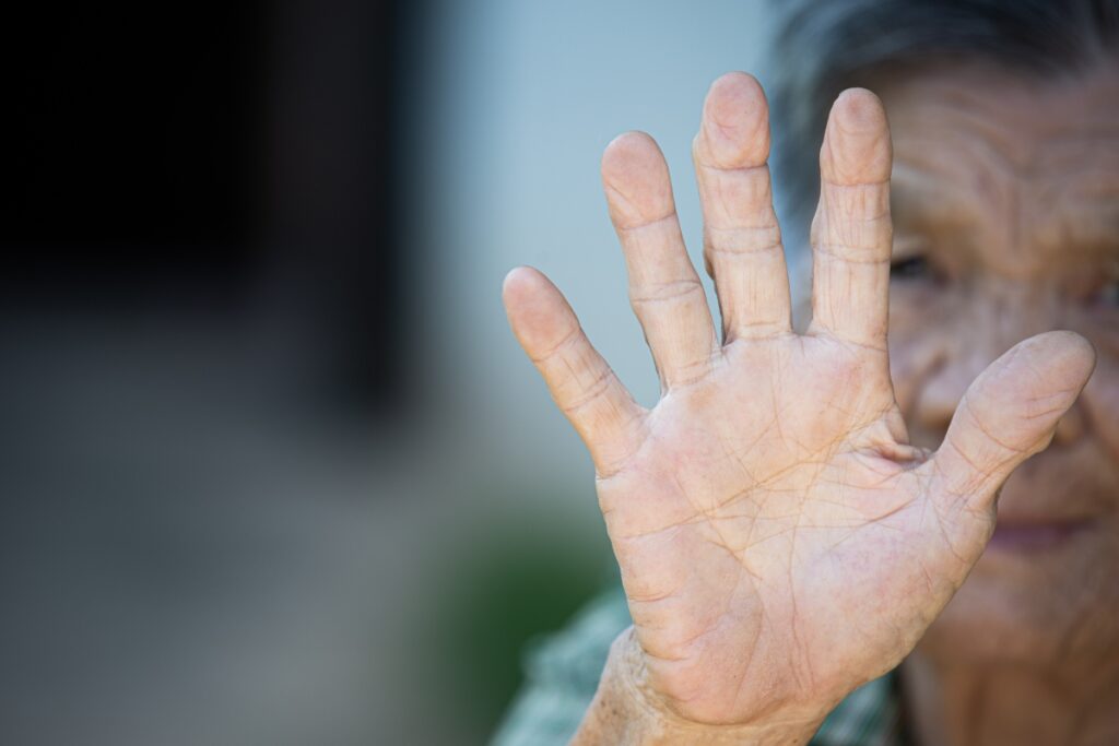 close up picture of old woman’s hand showing anti symbol invalidacao-dos-idosos