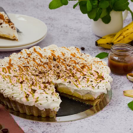 Traditional Banoffee pie with fresh bananas, whipped cream, chocolate, coffee and toffee. No baking dessert. Horizontal orientation.