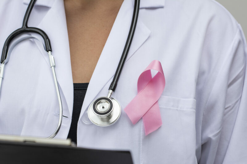 medico con cinta rosa para apoyar la causa del cáncer de mama