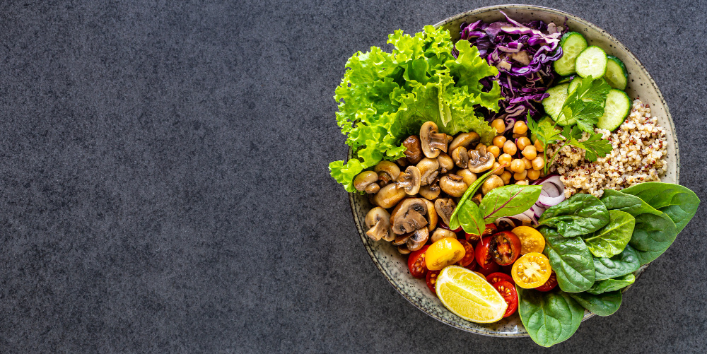 quinoa-mushrooms-lettuce-red-cabbage-spinach-cucumbers-tomatoes-a-bowl-of-buddha-on-dark-top-view