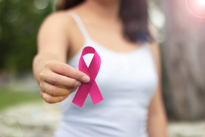 Woman,Holding,Pink,Ribbon,On,Light,Background,,Closeup.,Breast,Cancer