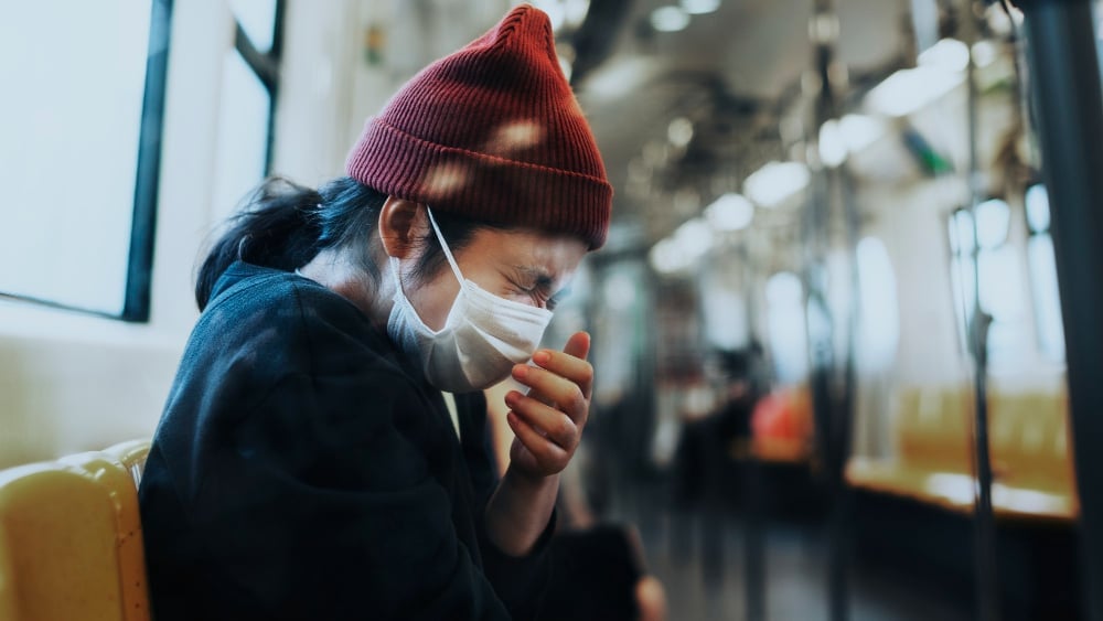 sick-woman-in-a-mask-sneezing-in-a-train-during-coronavirus-pandemic