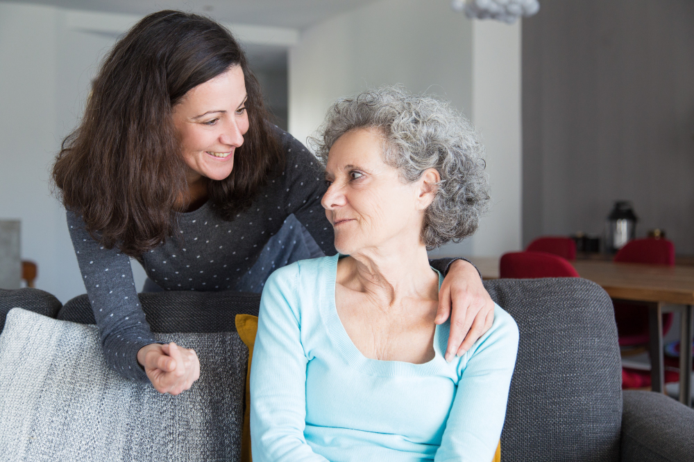 smiling-adult-daughter-supporting-sad-senior-mother
