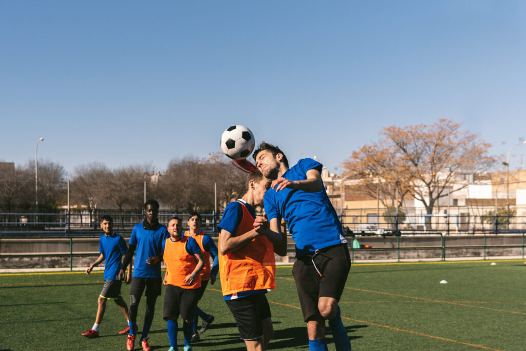 striker heads a football against a defender’s opposition striker heads a football against a defender’s opposition