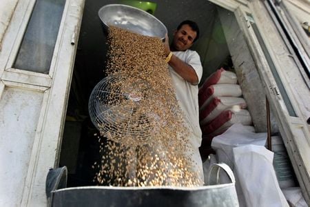 Homem separa trigo para venda em mercado em Riad, Arábia Saudita