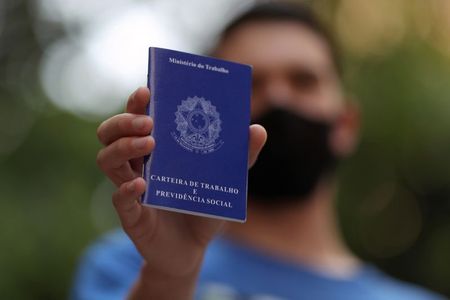 Homem mostra carteira de trabalho ao procurar por oportunidades de emprego no centro de São Paulo Homem mostra carteira de trabalho ao procurar por oportunidades de emprego no centro de São Paulo