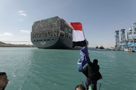 Homem chacoalha bandeira do Egito ao ver o navio Ever Given liberado após dias encalhado no Canal de Suez