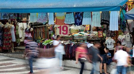 Pessoas caminham em frente a uma loja em uma rua comercial no centro de São Paulo. 04/12/2014. REUTERS/Paulo Whitaker. Pessoas caminham em frente a uma loja em uma rua comercial no centro de São Paulo. 04/12/2014. REUTERS/Paulo Whitaker.