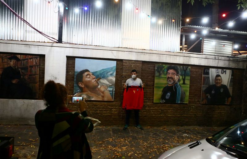 Pedestres tiram fotos de pinturas de Diego Maradona feitas pelo artista Maximiliano Bagnasco em Buenos Aires Pedestres tiram fotos de pinturas de Diego Maradona feitas pelo artista Maximiliano Bagnasco em Buenos Aires