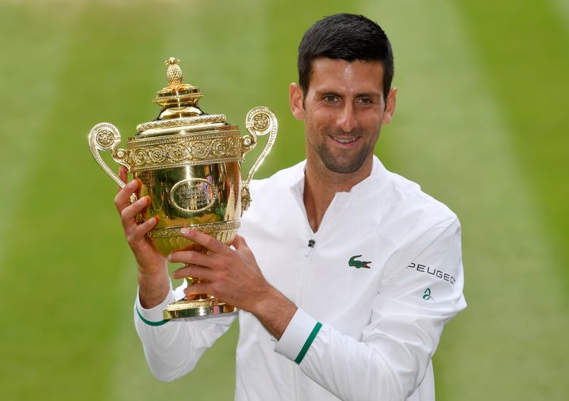 Novak Djokovic posa para foto ao lado do troféu de Wimbledon após conquistar o Grand Slam britânico em Londres