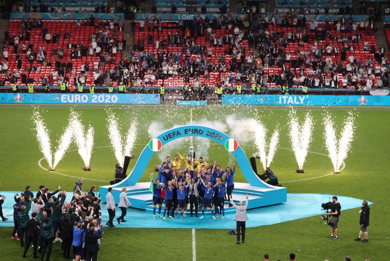 Jogadores da seleção da Itália comemoram conquista da Eurocopa com troféu no pódio em Wembley