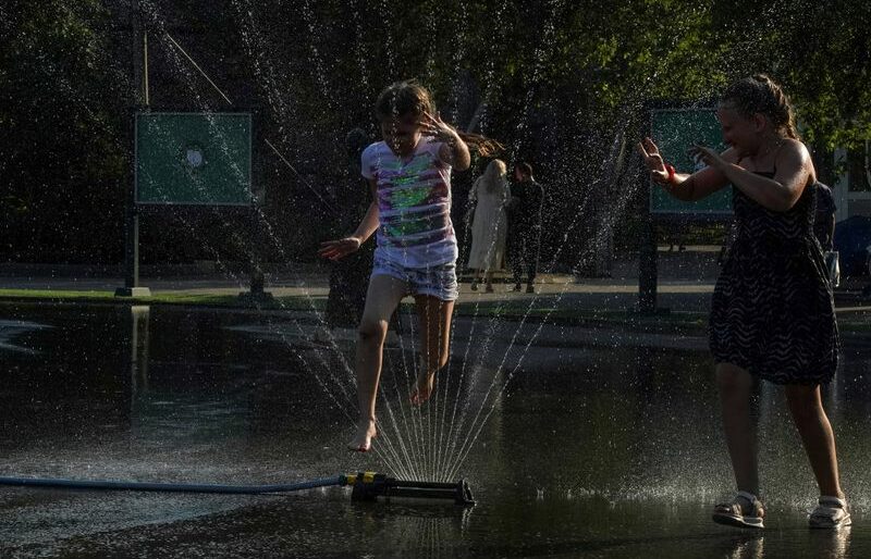 Crianças brincam com água em meio a forte calor em zoológico de Moscou