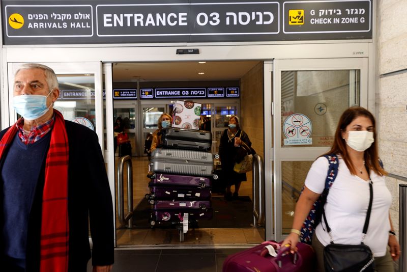 Pessoas usando máscaras saem do aeroporto de Tel Aviv em meio à pandemia de Covid-19
