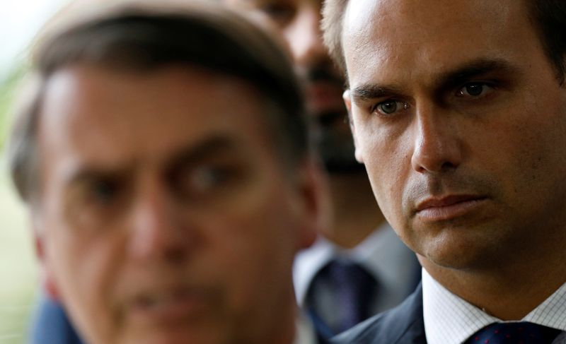 Eduardo Bolsonaro, son of Brazil’s President-elect Jair Bolsonaro is seen behind him at the transition government building in Brasilia