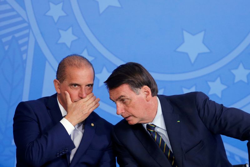 Bolsonaro e Onyx conversam durante cerimônia no Palácio do Planalto