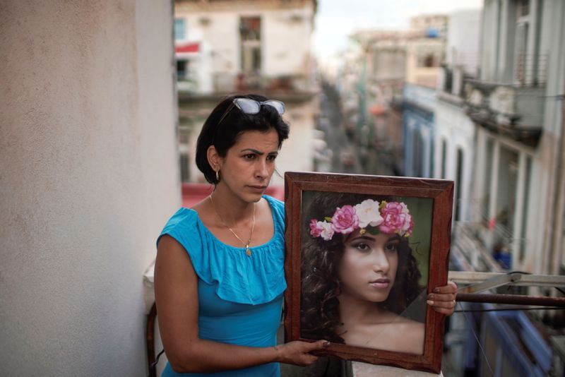 Heissy Celaya posa com retrato da filha Amanda Celaya, que foi detida durante protestos em Havana Heissy Celaya posa com retrato da filha Amanda Celaya, que foi detida durante protestos em Havana