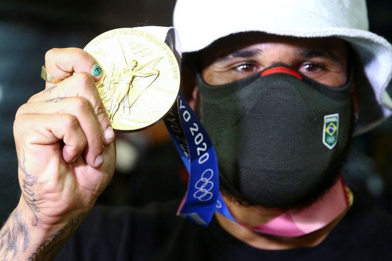 Ítalo Ferreira mostra medalha de ouro na chegada ao Brasil