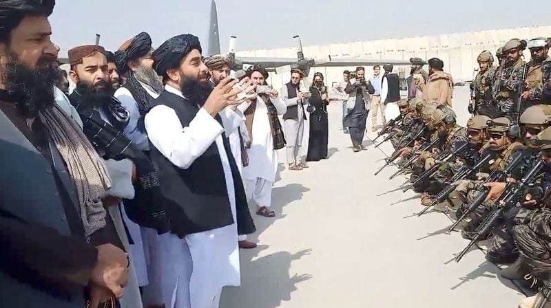 Porta-voz do Taliban Zabihullah Mujahid fala com membros de unidade militar no aeroporto de Cabul, no Afeganistão