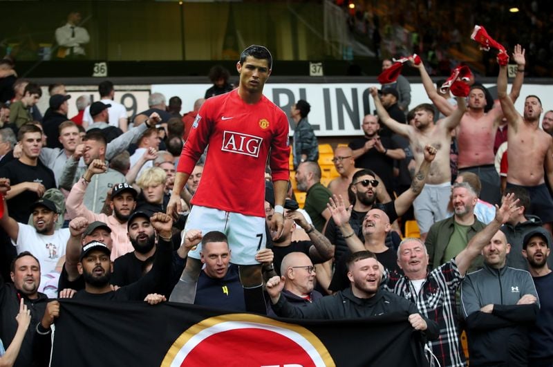 Torcedores do United com cartaz de Cristiano Ronaldo