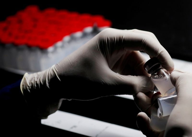 Agente de laboratório segura frasco da vacina contra a Covid-19 da Sinovac em Cairo