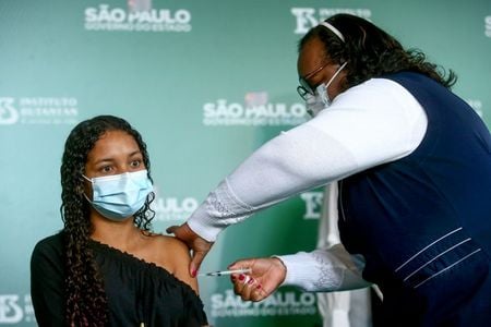 Jovem recebe vacina contra Covid-19 em São Paulo