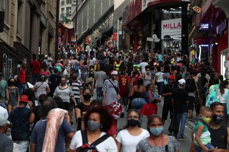 Cosumidores fazem compras em rua comercial de São Paulo em meio a disseminação da Covid-19