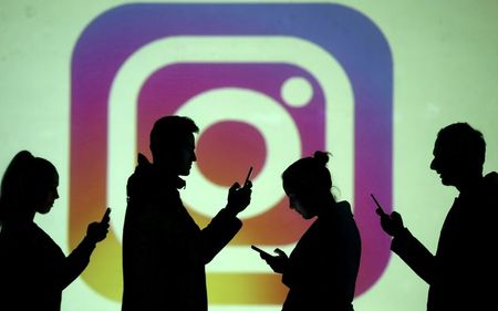 Silhuetas de pessoas usando smartphones, com logotipo do Instagram ao fundo