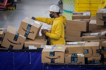 Funcionário escaneia pacotes no centro de distribuição JFK8 da Amazon em Staten Island, Nova York, EUA