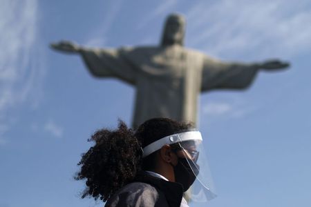 Guarda usa máscara e protetor facial na estátua do Cristo Redentor, no Rio de Janeiro