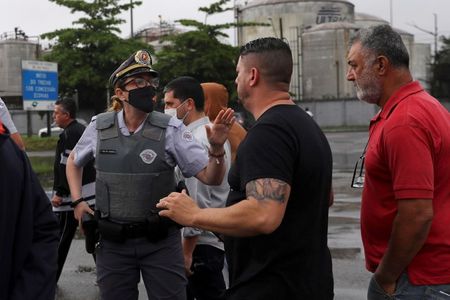Caminhoneiros conversam com policial durante protesto em Santos