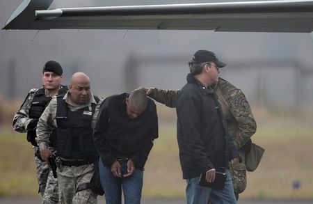 Adélio Bispo de Oliveira, de cabeça baixa, é escoltado em aeroporto de Juiz de Fora