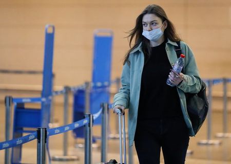Mulher usando máscara de proteção caminha na área de embarque do aeroporto de Vnukovo, em Moscou Mulher usando máscara de proteção caminha na área de embarque do aeroporto de Vnukovo, em Moscou