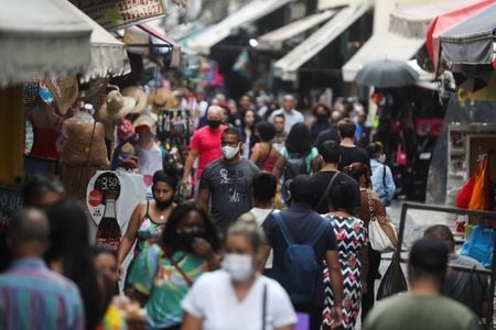 Pessoas caminham em rua de comércio popular no Rio de Janeiro