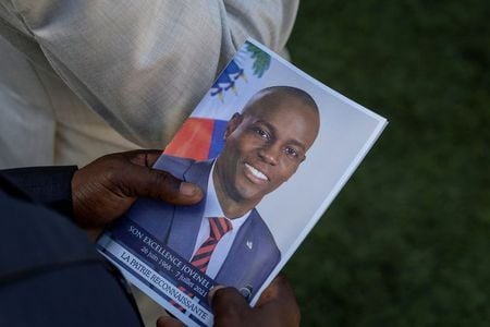 Pessoa segura foto do presidente assassinado do Haiti Jovenel Moise durante seu funeral em Cap-Haitien