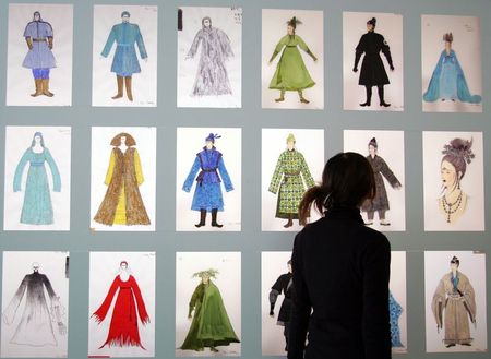 Mulher olha exposição de figurinos desenvolvidos por Emi Wada, em Tóquio